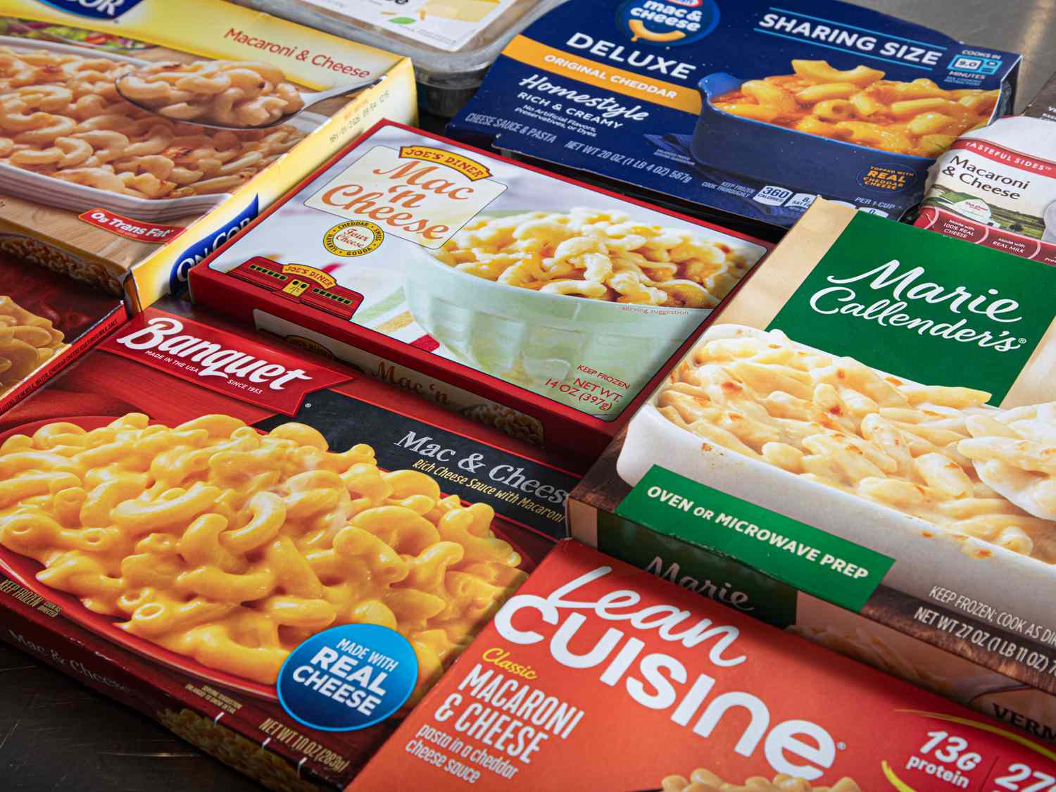 Various brands of frozen macaroni and cheese packages spread out