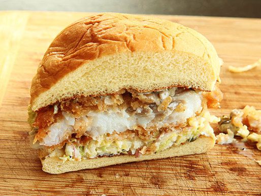 Half of a fried fish sandwich with creamy slaw and tartar sauce.
