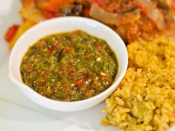 A small bowl of Puerto Rican sofrito next to rice on a plate.
