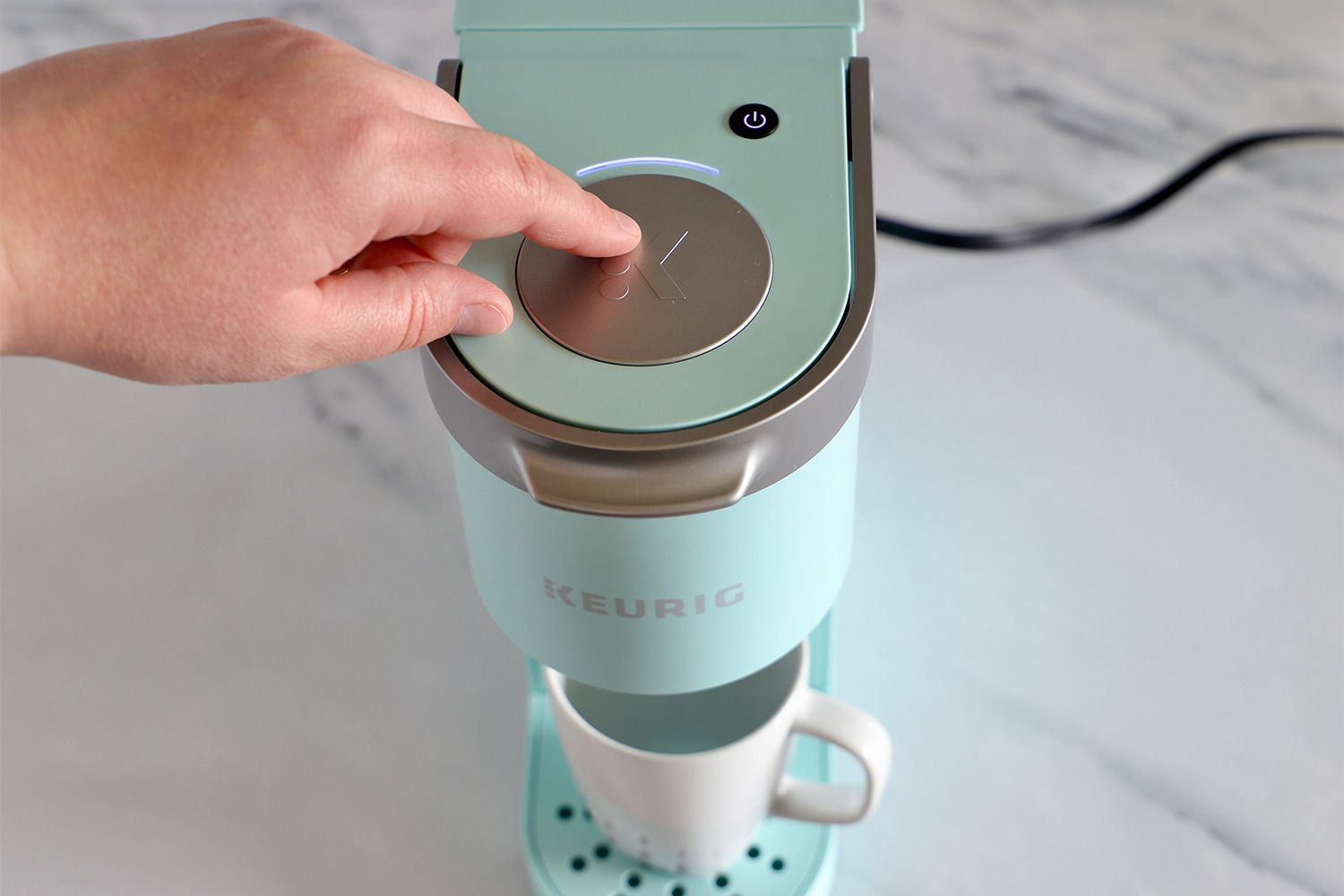 Keurig coffee machines k mini single on counter being used by person 