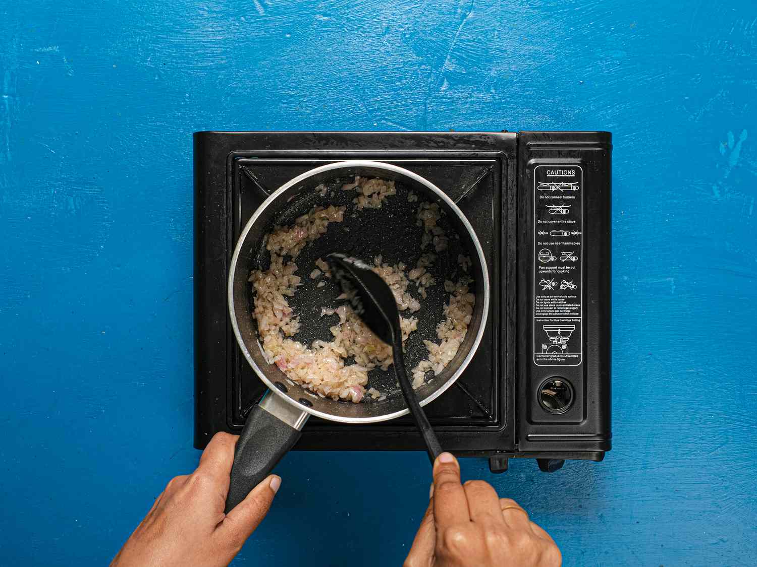 sauteeing shallot in saucepan and mixing with a spoon