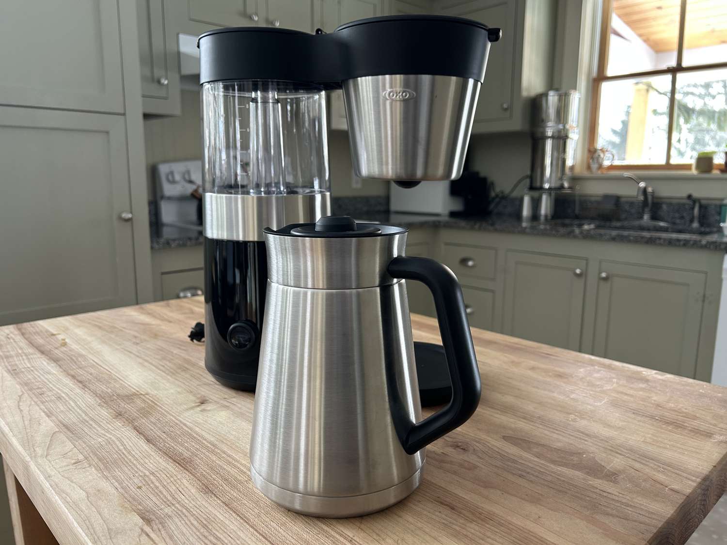 The OXO Brew 9-Cup Coffee Maker on a wooden surface in a kitchen.