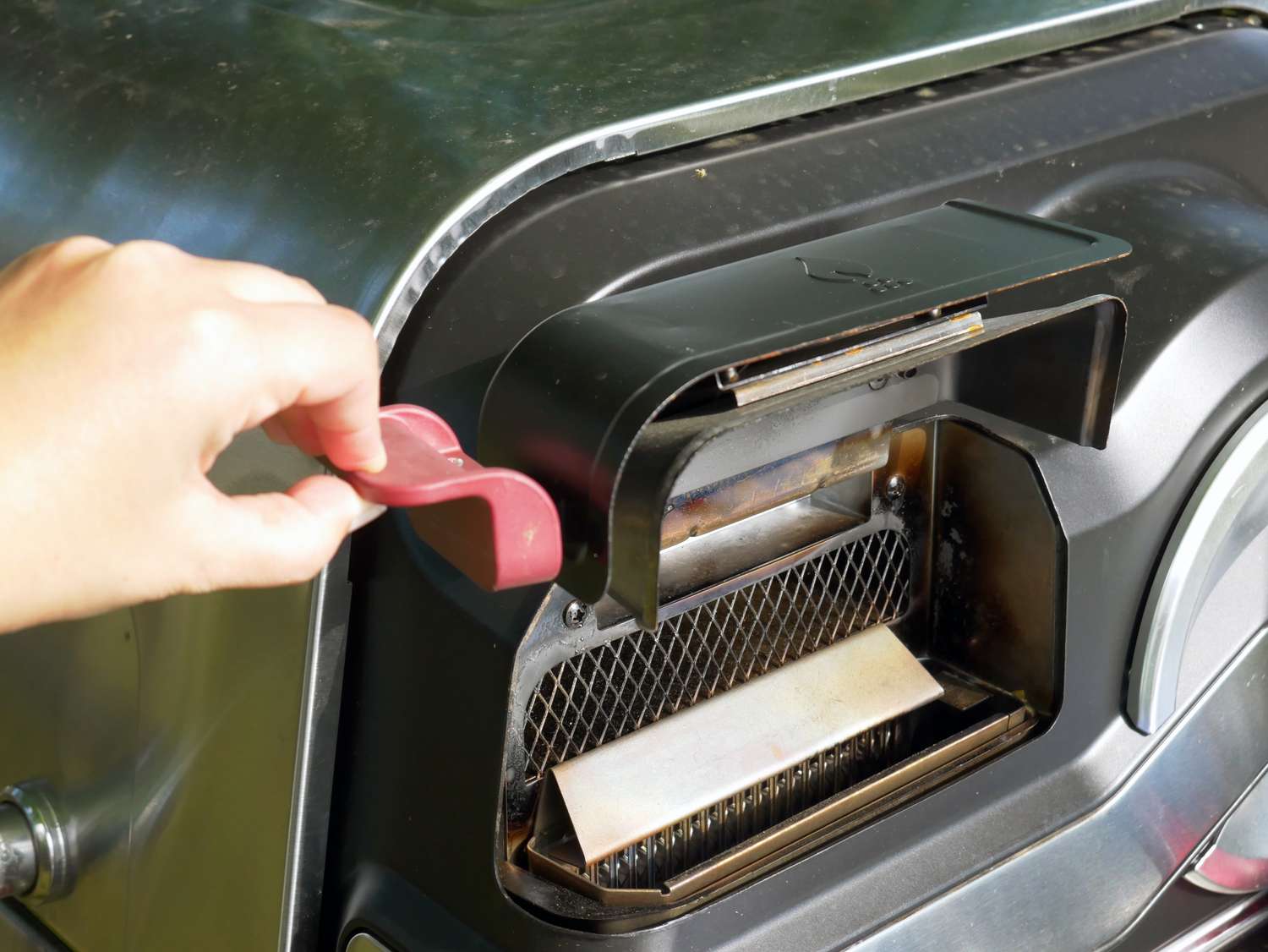 a person opening the hopper on the ninja flexflame