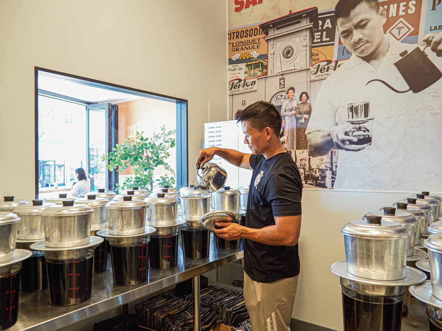 Pouring hot water into a large phin filter set over a large cambro.