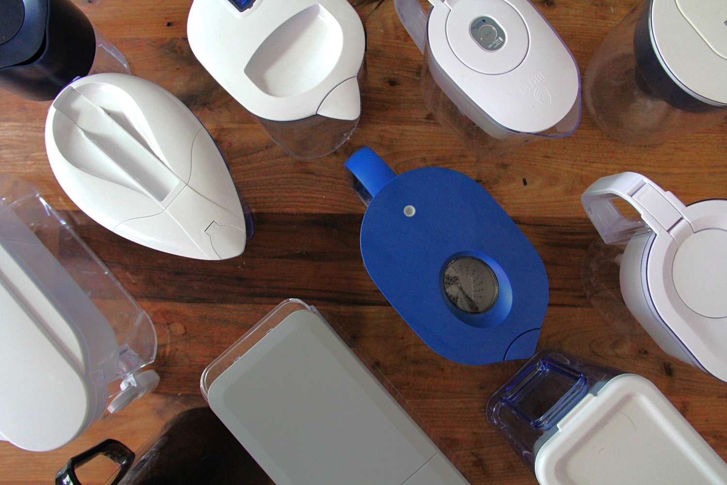 an overhead view of water filter pitchers and dispensers on a wooden surface