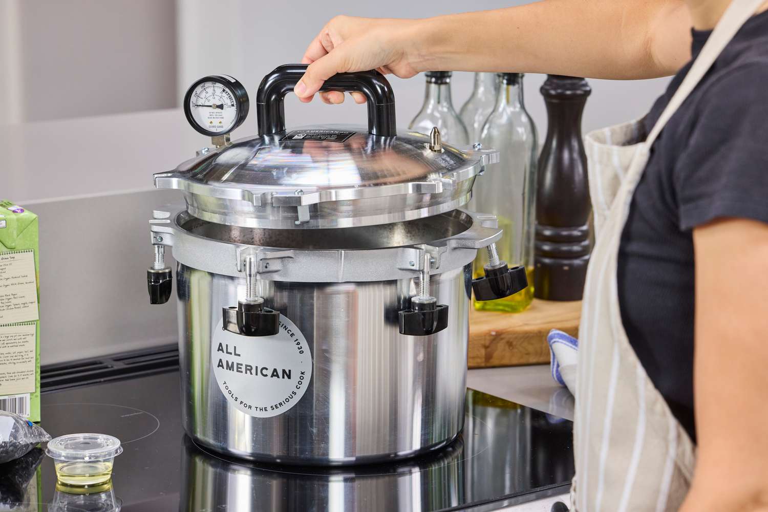 A person holding the lid of the All American 10.5 Quart Pressure Cooker & Canner