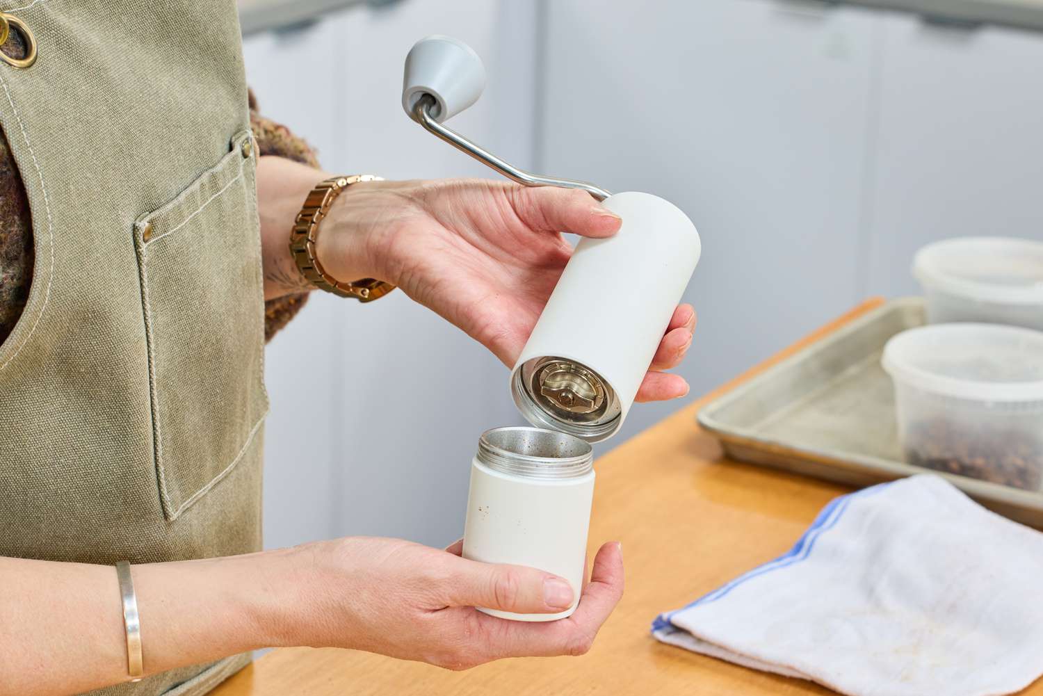A person removes the bottom from the Timemore C2 Max Manual Grinder