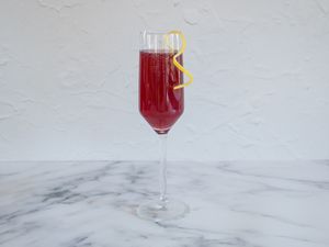Pomegranate rouge cocktail garnished with a lemon twist.