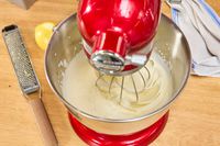 A person makes whipped cream in the KitchenAid Artisan Mini 3.5-Quart Tilt-Head Stand Mixer
