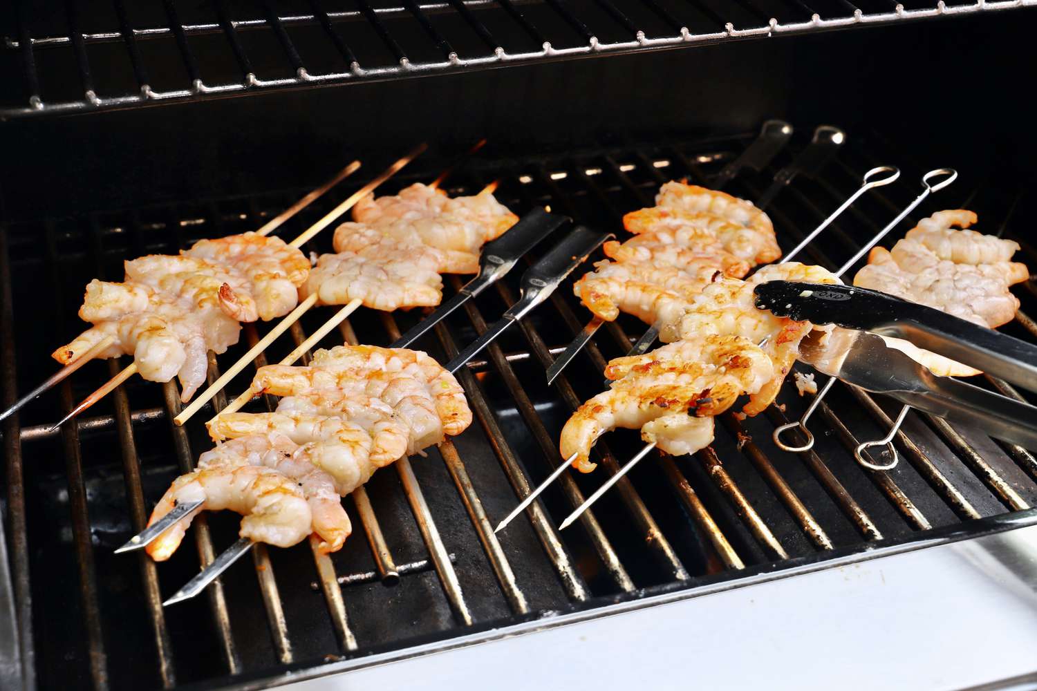Shrimp skewers being cooked on a gas grill