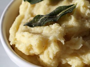 A bowl of parsnip puree with olive oil and sage. 
