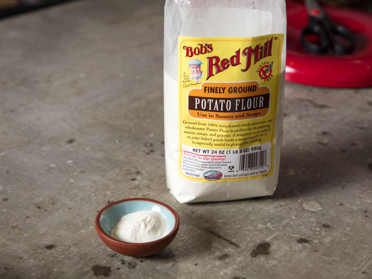 An open bag of potato flour, next to a small pinch bowl of potato flour.