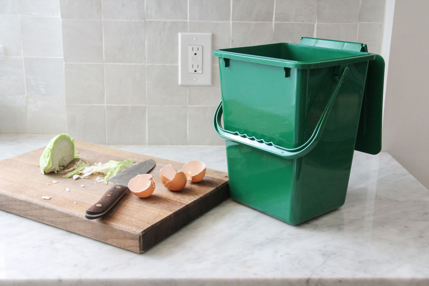 Exaco Eco 2000 kitchen compost pail on a counter next to a cutting board