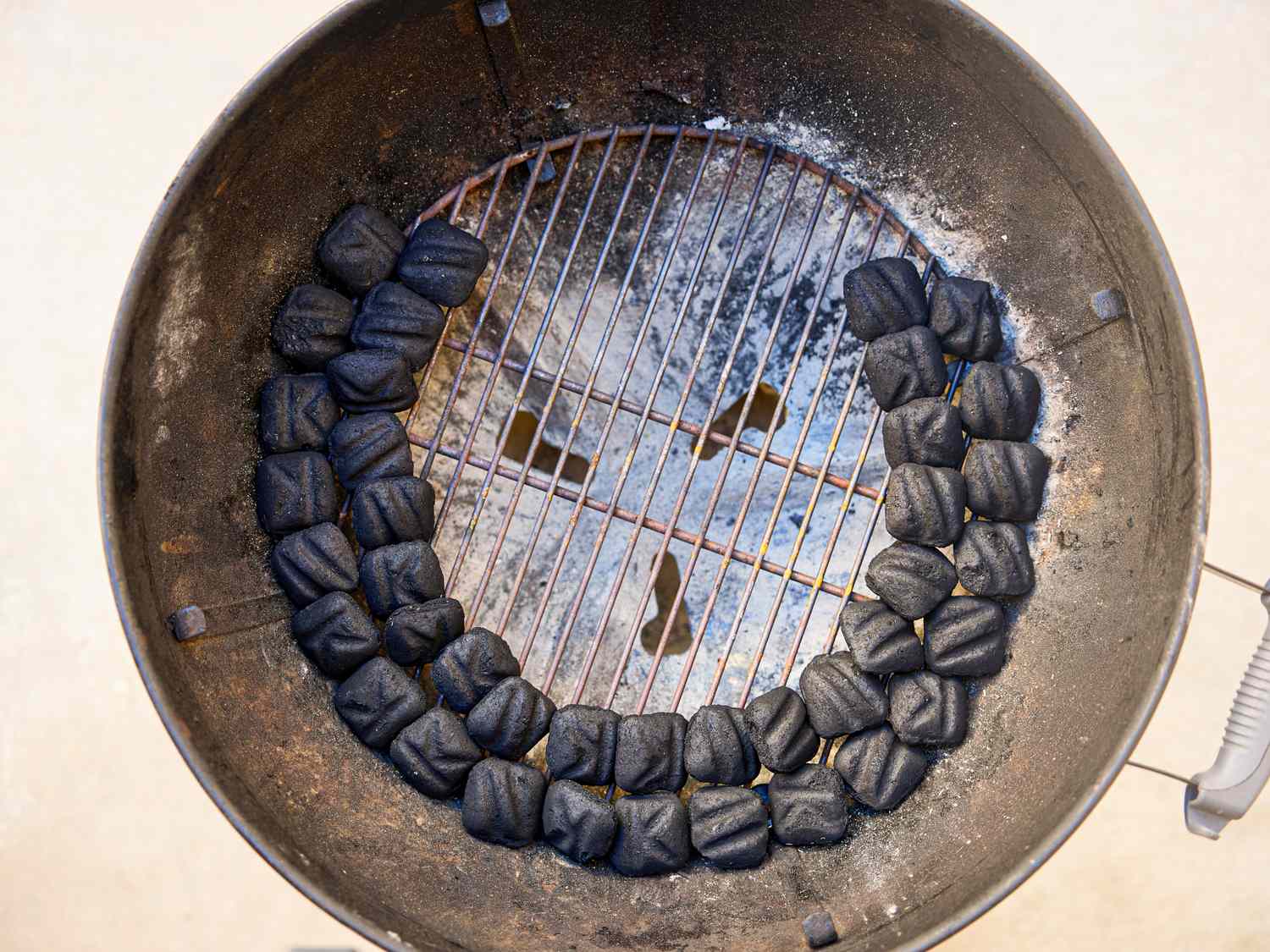 Charcoal arranged in a circular pattern inside a grill