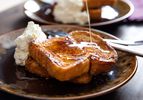 Orange-rum challah French toast, served with whipped crème fraîche and drizzled with maple syrup.
