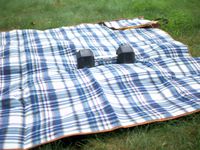 elba oniva picnic blanket with a weight on it in the grass