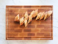 A sliced baguette on a wooden carving board