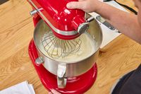 A person whips cream in the KitchenAid 7 Quart Bowl Lift Stand Mixer