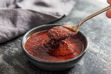Spooning dried chile harissa from a bowl