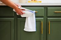 A person drying their hands with the Zeppoli kitchen towel.
