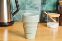 A Stojo travel cup on a kitchen countertop.