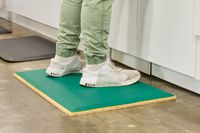 A person stands on the Fulton Standing Mat
