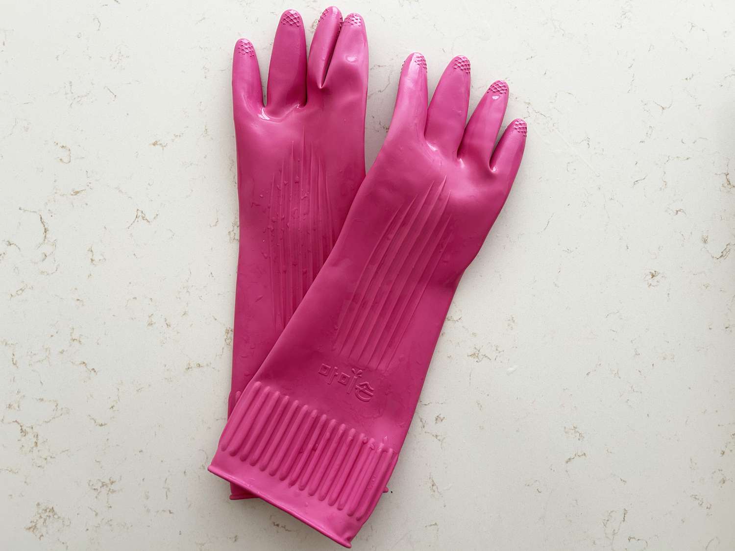 A pair of pink gloves on a white countertop