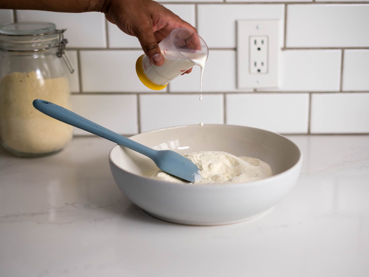 Pouring cream into a bowl of semolina for gulab jamun dough