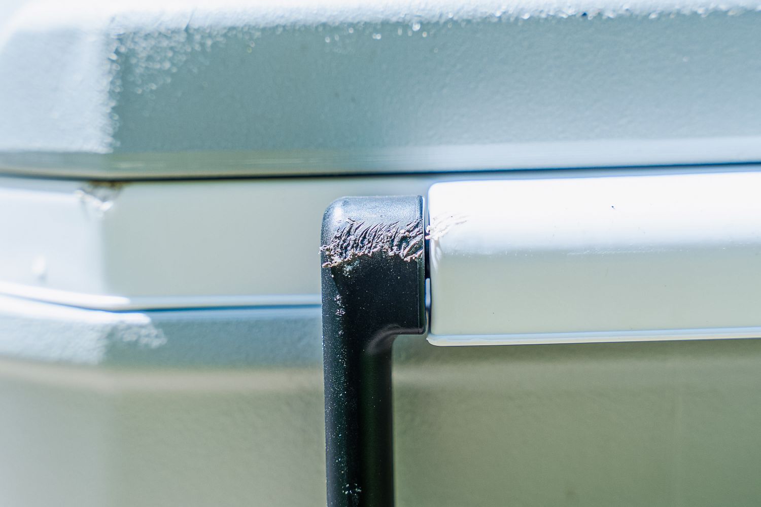 A closeup of the Coleman Classic cooler, focusing on the scuffed handle