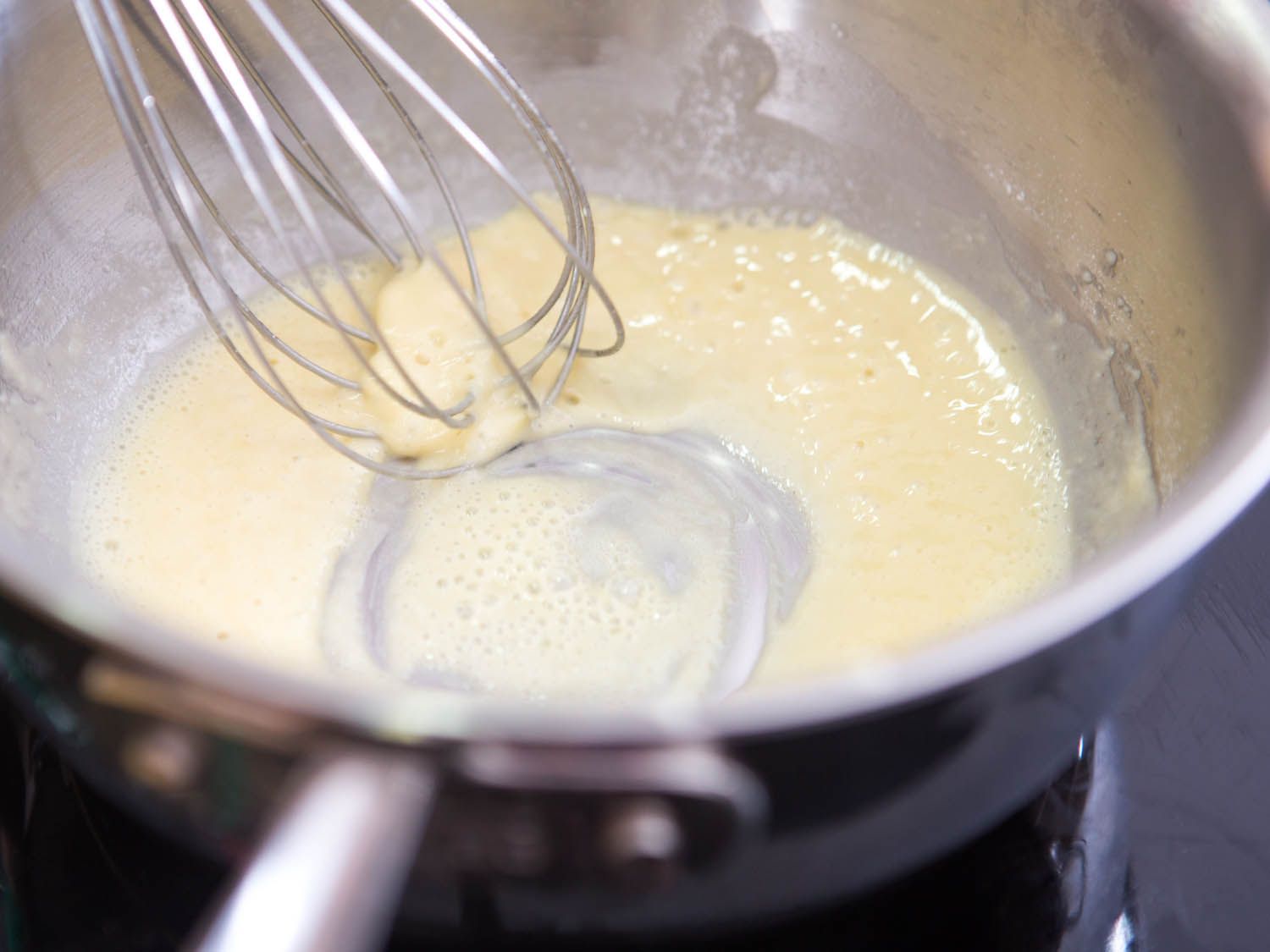 Whisking roux in a saucepan for Swedish meatball gravy.