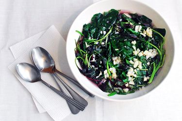 A bowl of spinach and red shen choy in garlicky broth.