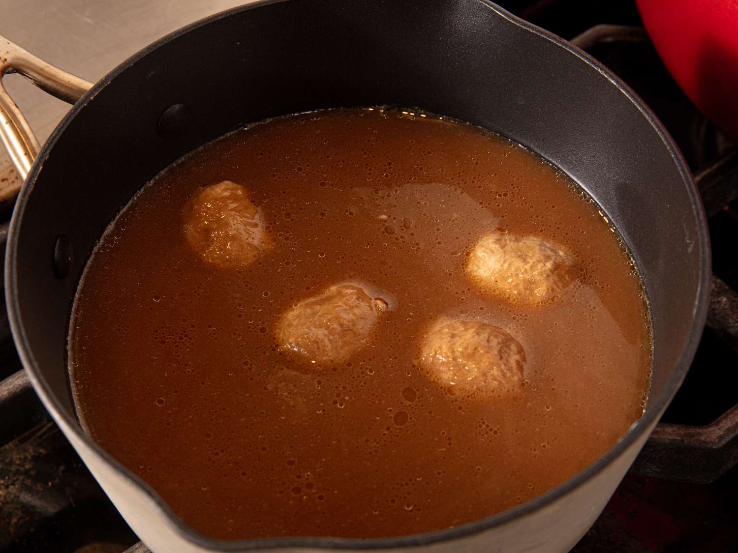 Overhead view of meatballs in broth