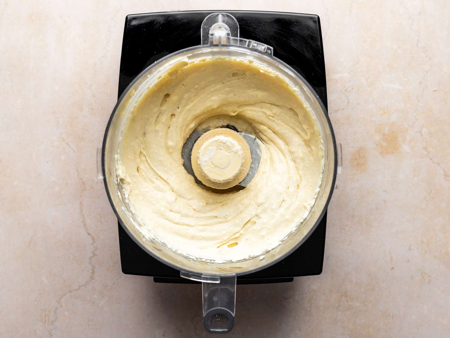 The ricotta, mixed, inside of the food processor.