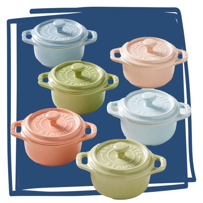 Six pastelcolored Staub mini cocottes arranged in two rows on a blue background