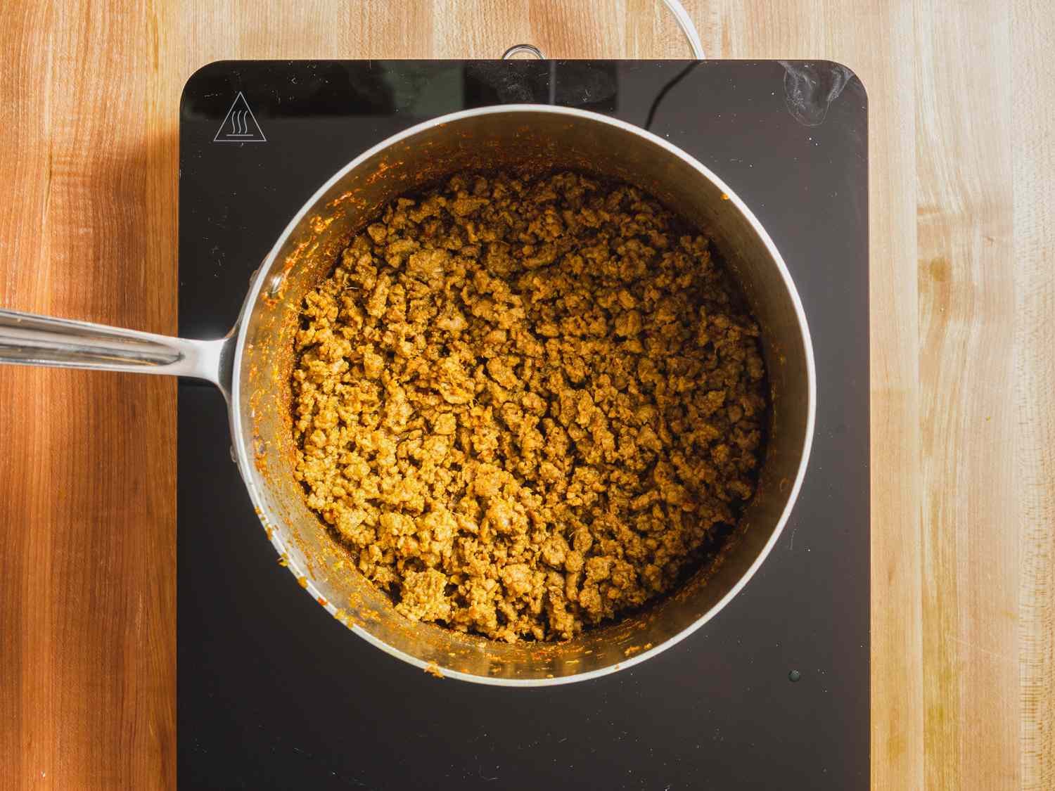 Overhead view of lamb kheema being prepared in a saucepan.
