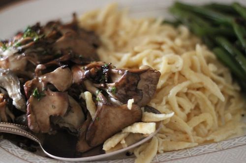 Spätzle plated with sautéed maitake mushrooms and green beans.