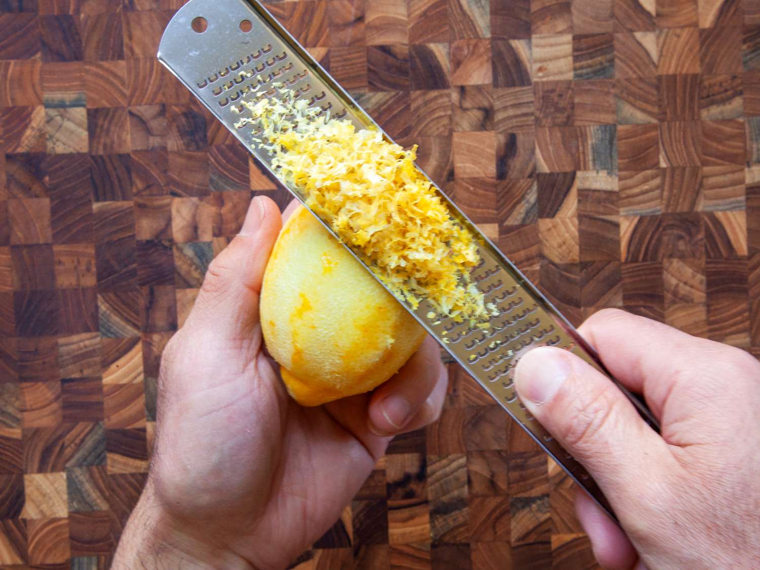 Person using the microplane classic zester to zest a lemon