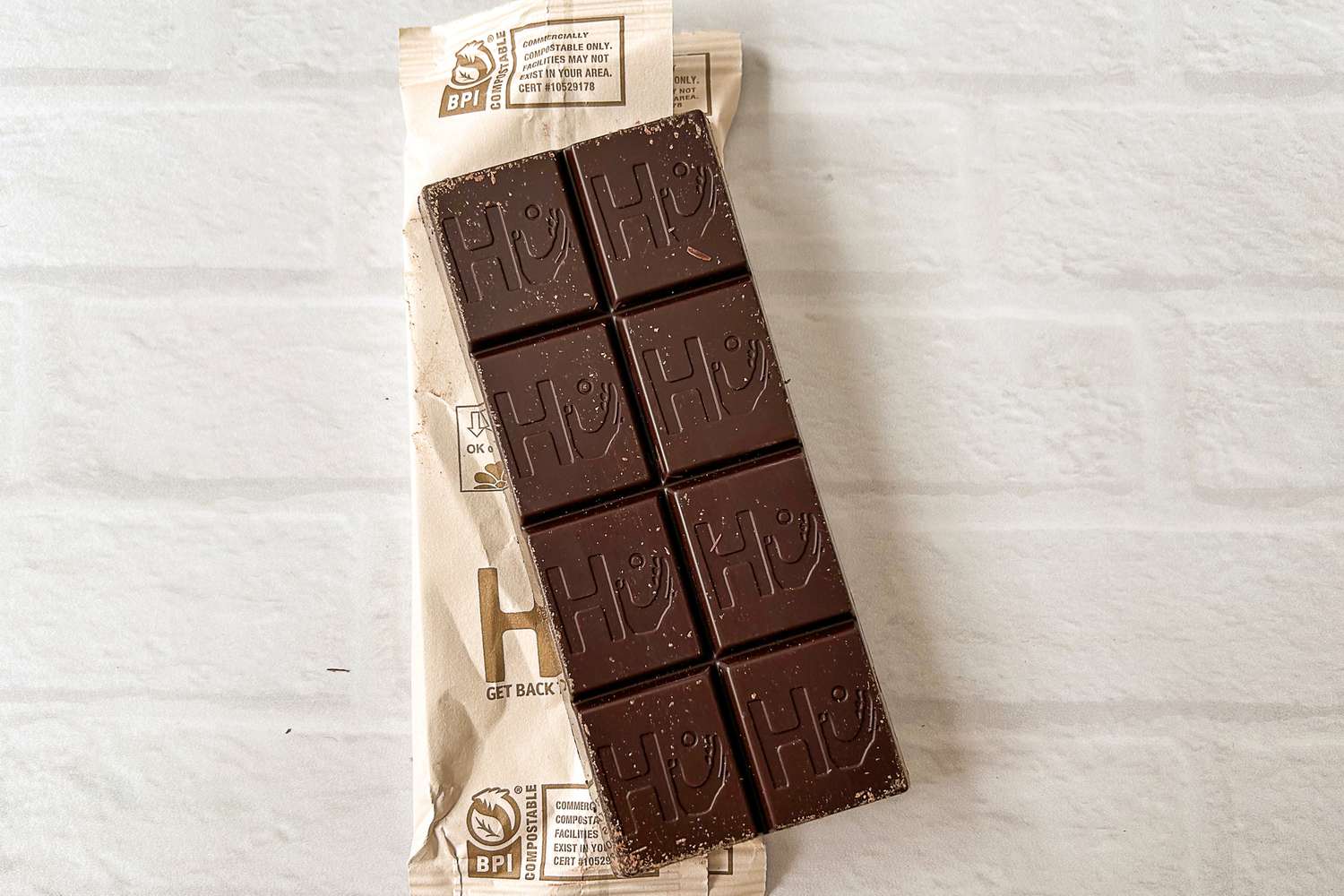  Hu Simple Dark Chocolate on a white brick surface
