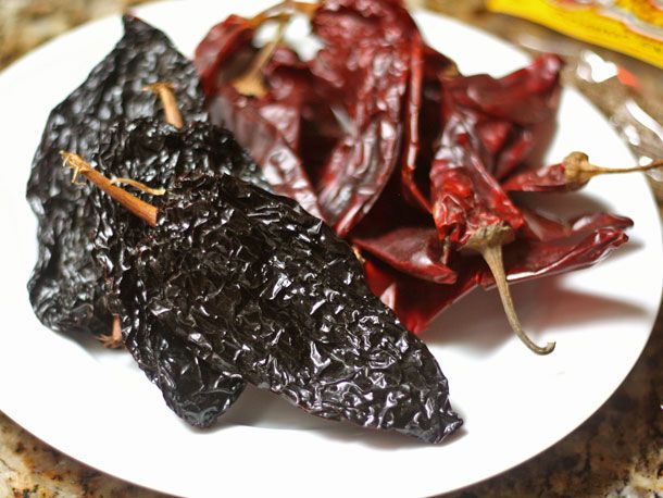 Dried Ancho, New Mexico, and Arbol chiles on a white plate.