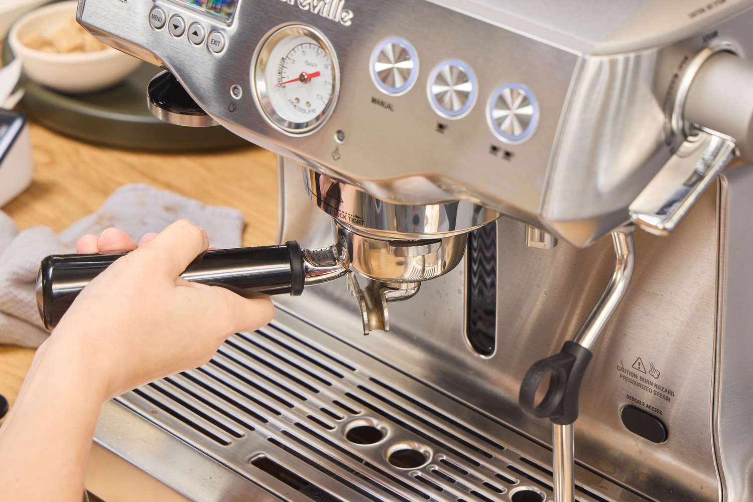 A person makes espresso using the Breville BES920XL Dual Boiler Espresso Machine