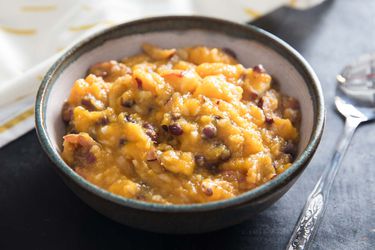 A bowl of hobak beombeok, showing its warm autumnal colors, a thick, slightly chunky, porridge-like consistency.