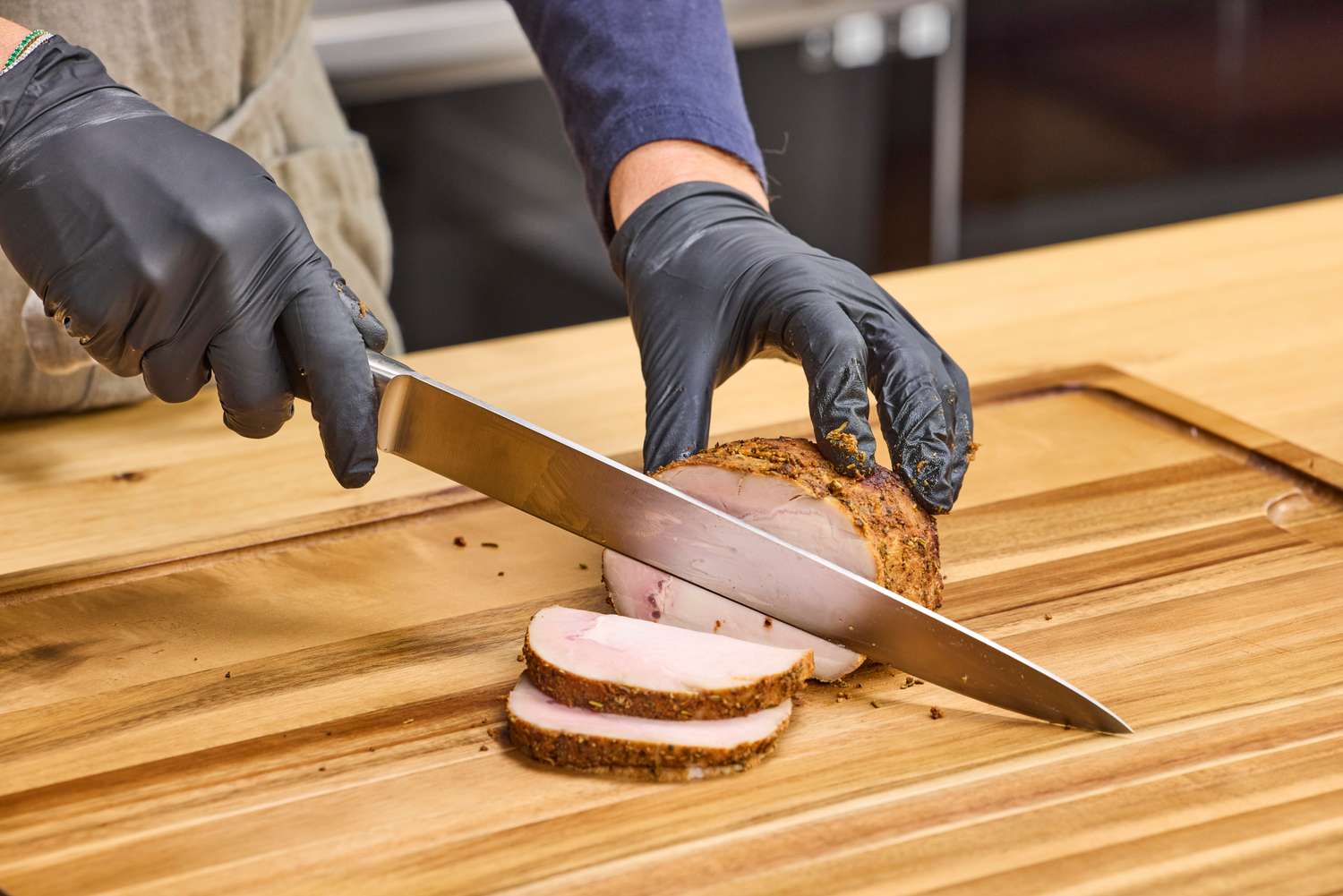 A person slices meat with the Mercer Culinary 10-Inch Carving Knife