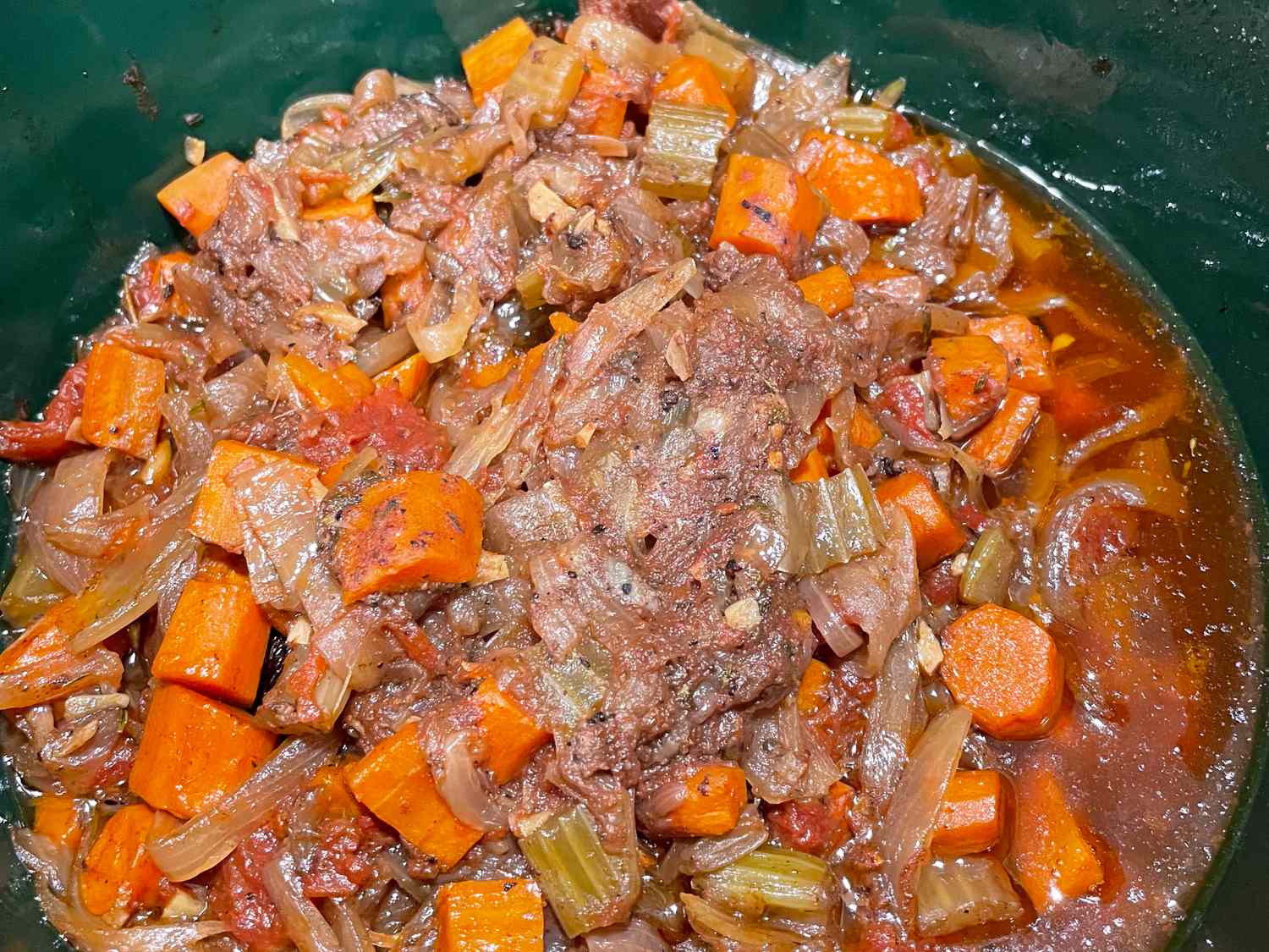 Cooked dish featuring meat carrots celery and a broth or sauce
