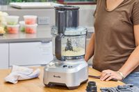 A person uses the Breville BFP660SIL Sous Chef 12-Cup Food Processor