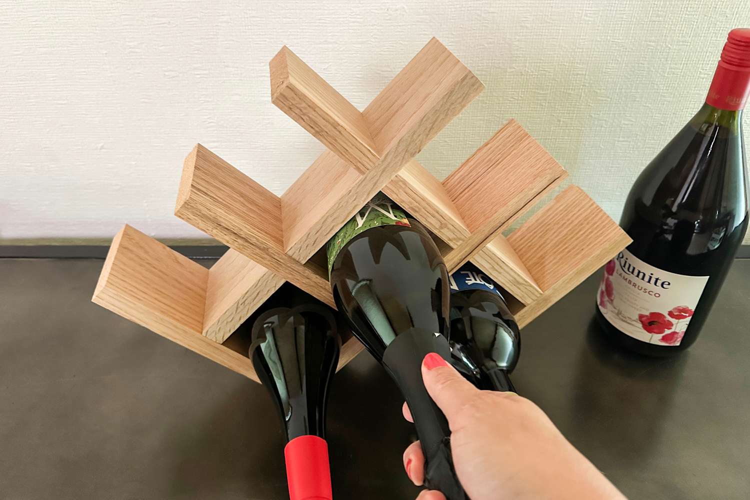 A wooden wine rack that's too small to fit a bottle of wine.