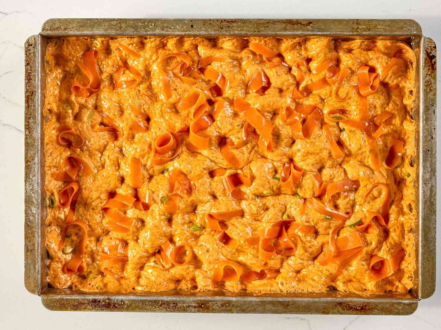 Baked carrot focaccia bread in a rectangular tray