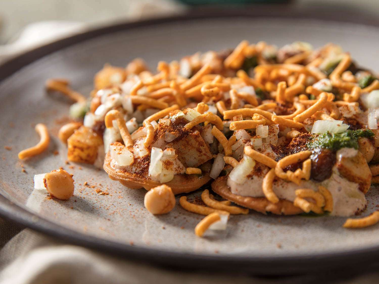 A ceramic plate holding composed papri chaat.
