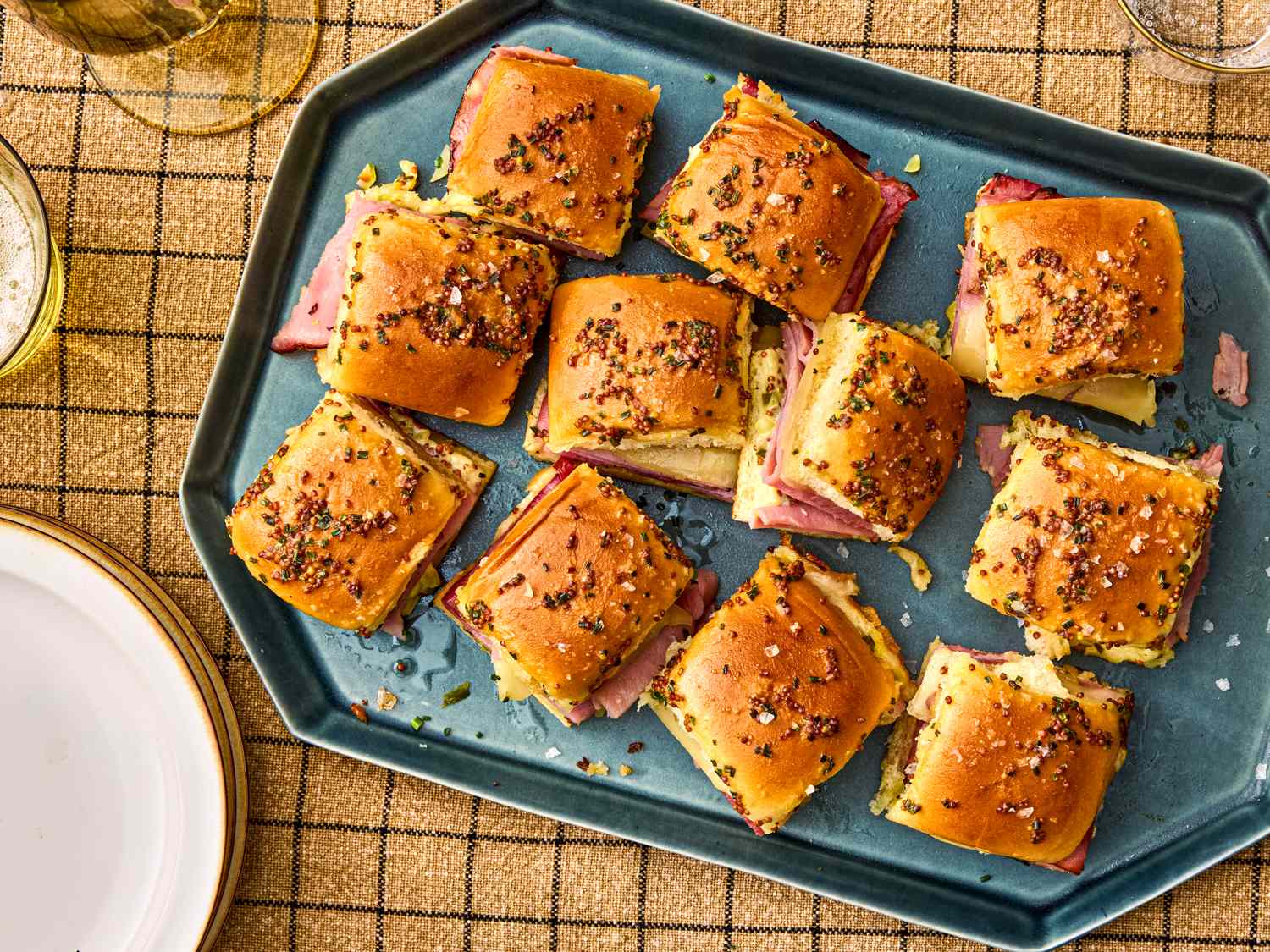Tray of ham and cheese sliders with a topping of seeds