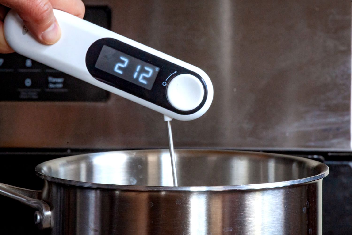 A person using the OXO thermometer to take the temperature of boiling water.
