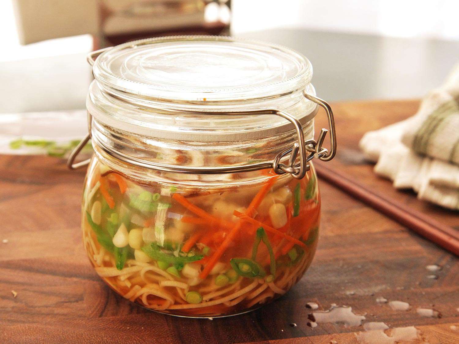 A closed clip top jar of steeping homemade instant noodles. 